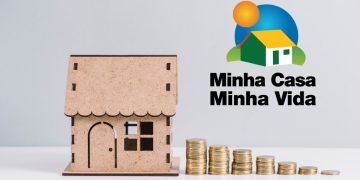 casa em miniatura ao lado de moedas e a logo do programa habitacional. Ilustrativa para Simulação Minha Casa Minha Vida.