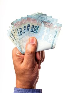 notas-de-100-reais-do-brasil-seguradas-por-mao-masculina-isoladas