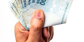 notas-de-100-reais-do-brasil-seguradas-por-mao-masculina-isoladas
