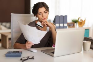 Mulher conferindo suas dívidas para participar do Tudo em Dia Caixa.