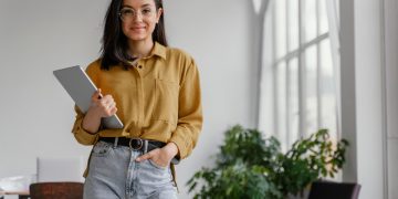 Mulher com tablet em sua mão, cuidando do negócio e descobrindo como comprovar renda sendo mei.