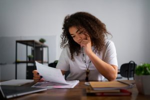 Mulher conferindo boletos ao descobrir o que é DDA e como ele pode ajudar. 