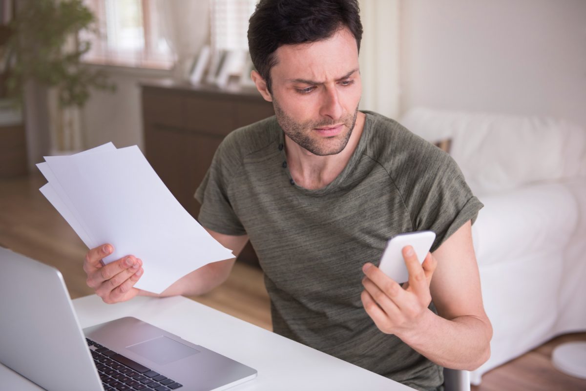 Homem tentando renegociar dívidas ao entender como evitar superendividamento.