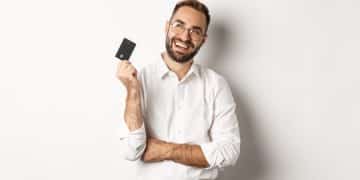 Hombre feliz con Tarjeta Banco Internacional Mastercard.
