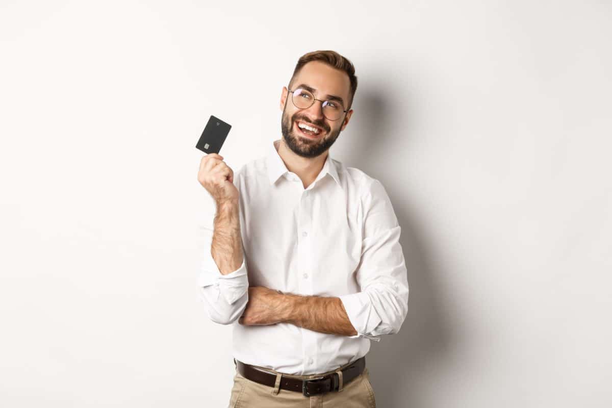 Hombre feliz con Tarjeta Banco Internacional Mastercard.