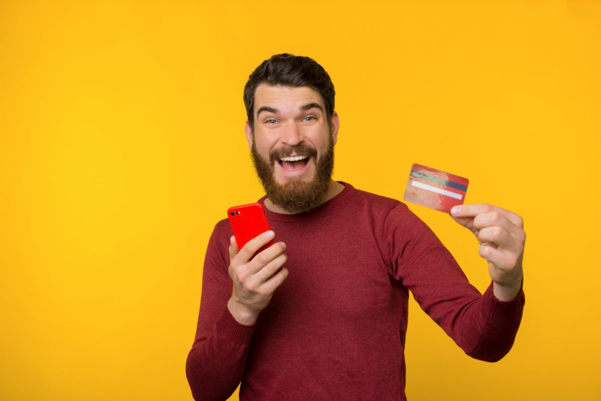 Hombre feliz com Tarjeta Santander Mastercard.