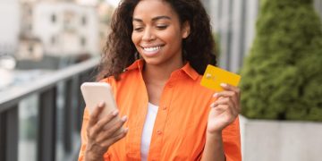 Mujer feliz usando tarjeta Visa Smart Estado.