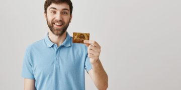 Hombre feliz com su tarjeta chile mastercard gold.