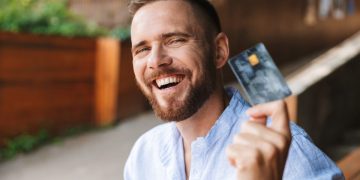 Hombre feliz usando tarjetas de crédito en Colombia.