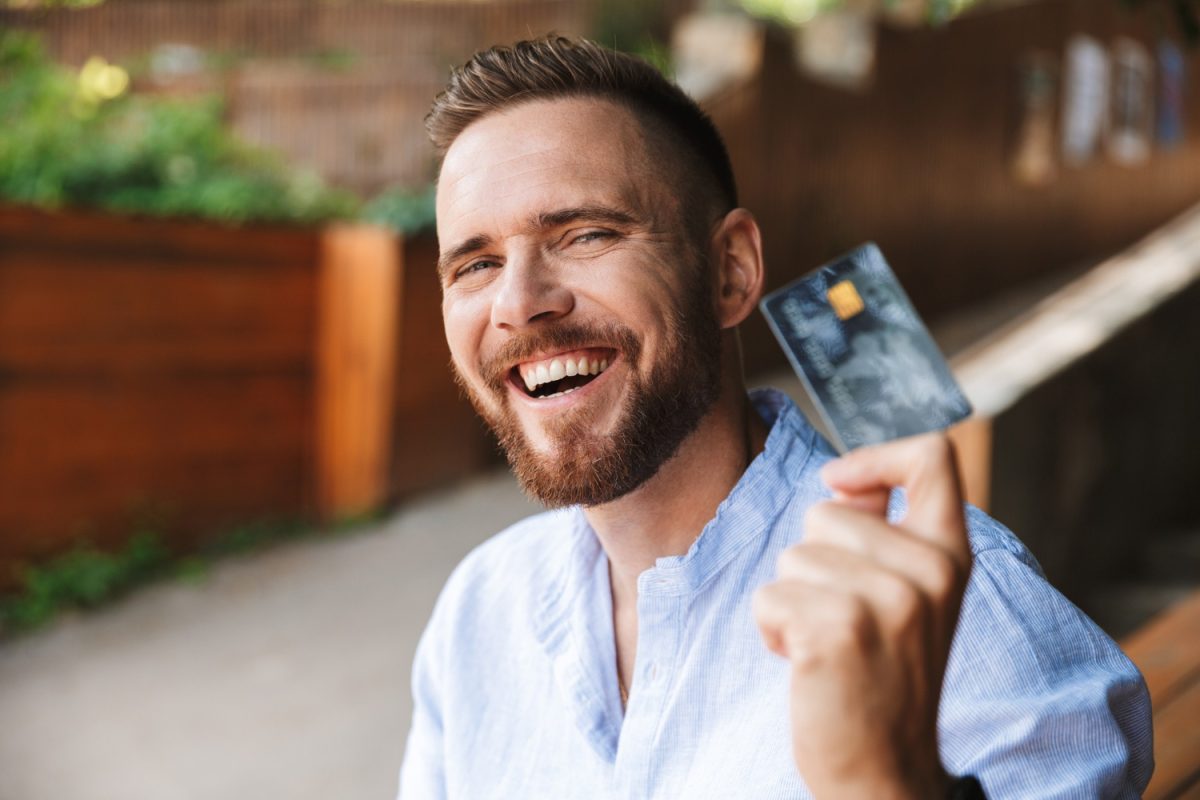 Hombre feliz usando tarjetas de crédito en Colombia.