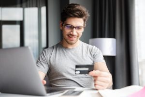 Hombre feliz usando Tarjeta Coopeuch Mastercard.