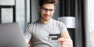 Hombre feliz usando Tarjeta Coopeuch Mastercard.