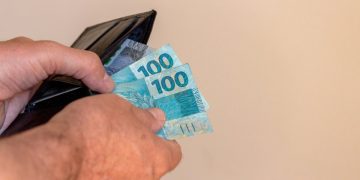 Pessoa segurando salário ao descobrir quem tem direito ao 13º salário.