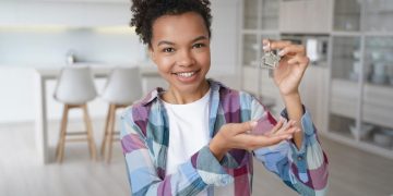 Mulher feliz com a chave da própria casa ao aprender Como se inscrever no Minha Casa Minha Vida 2024.