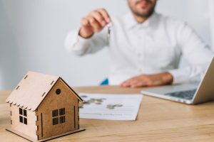 Homem segurando chave de imóvel depois de descobrir como financiar um terreno.