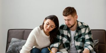 Casal fazendo cálculos com o FGTS Futuro para a compra de casa própria.