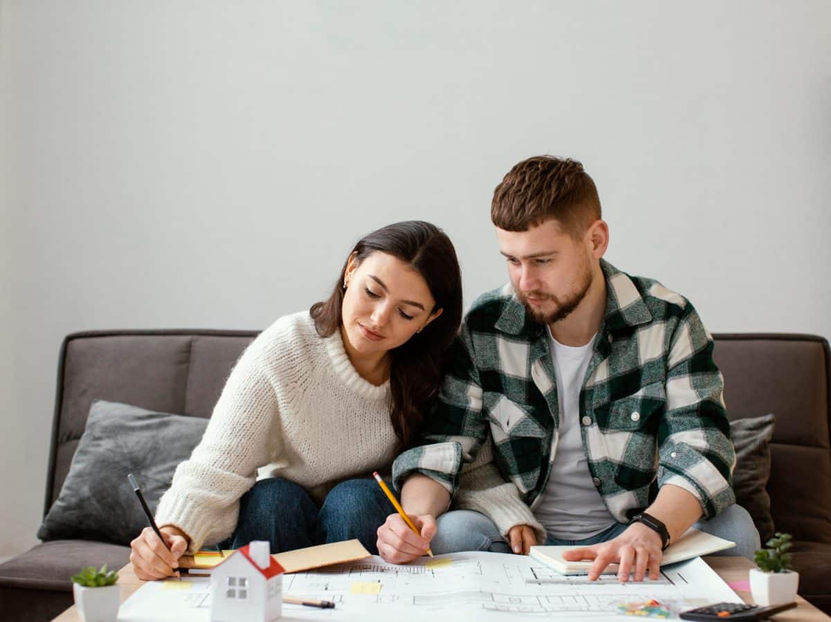 Casal fazendo cálculos com o FGTS Futuro para a compra de casa própria.