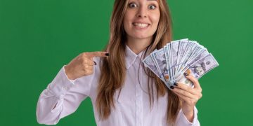 mujer sosteniendo dólares entendiendo el comportamiento del dólar.