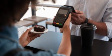 A person learning How to Use Apple Pay at store.