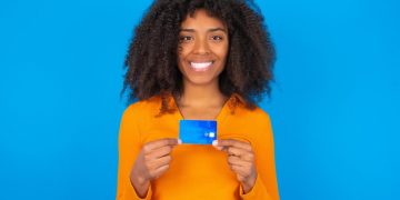 Happy woman holding her Capital One Platinum Credit Card.