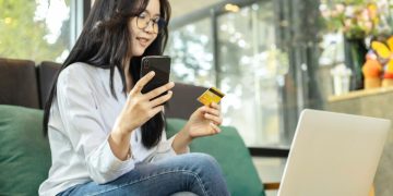 mulher usando bancos digitais no celular e computador.