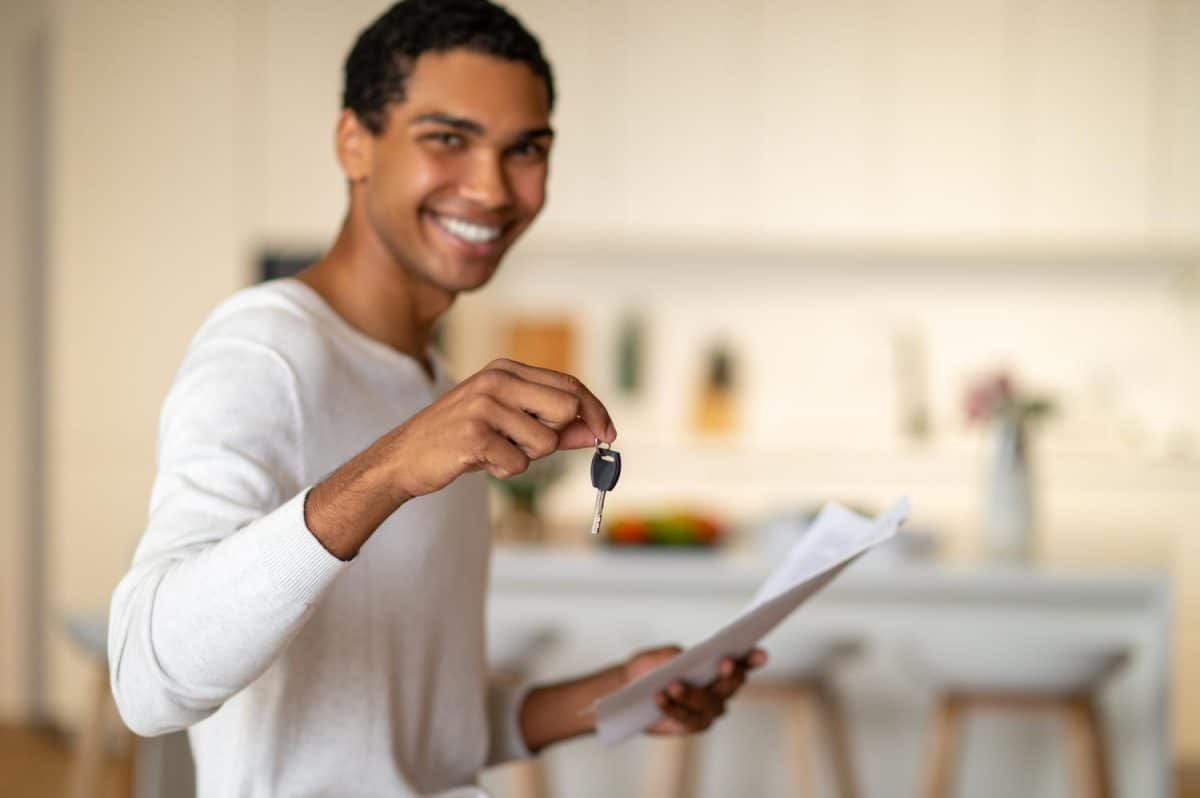 rapaz feliz ao escolher seguro fiança para alugar imóvel.
