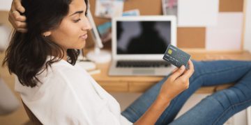 Mulher buscando descobrir como Diminuir a fatura do cartão de crédito.