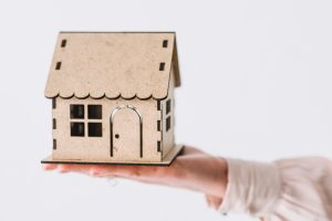 pessoa segurando miniatura de casa, representando brasileiros vivendo de aluguel.